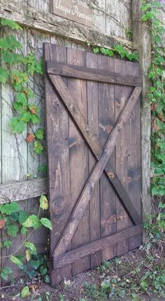 an old wooden gate with vines growing around it