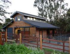 a small wooden house with a metal fence around it