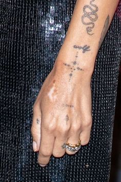 a close up of a person's arm with tattoos on it and a ring