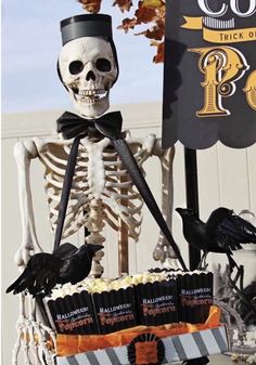 a skeleton sitting on top of a table with cupcakes