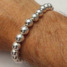 "These are very unique bracelets made from genuine metal beads.  This one has heavy, hollow 8mm sterling silver beads.  The length averages around 7\".  It is stretchy though, so it will probably fit between 6.5\" and 7.5\".  Larger and smaller size available upon special request. (Send me a note.) The beads are genuine and solid Sterling Silver.  There may be tiny dents on close inspection.  It can't be helped.  Do not drop or allow to bang against hard surfaces. These bracelets are extremely beautiful and can be worn by both men and women!" Silver Stretch Bracelet With 8mm Beads For Gift, Silver Stretch Bracelet With Polished Beads Gift, Everyday Silver Bead Stretch Bracelet, Classic Silver Round Beads Stretch Bracelet, Hypoallergenic Sterling Silver Stretch Bracelet In Silver, Hypoallergenic Sterling Silver Stretch Bracelet, Sterling Silver Bracelet With Hand-strung Round Beads, Silver Hand-strung Stretch Bracelet, Spiritual Silver Beaded Bracelets With Large Beads