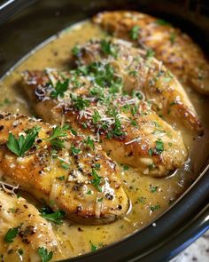 chicken with gravy and parmesan cheese in a slow cooker dish