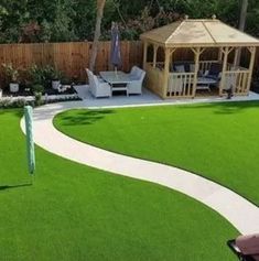 a backyard with artificial grass and a gazebo