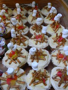 cupcakes with marshmallows and pretzels on them in a tray