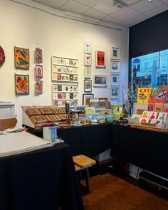 a room filled with lots of different types of art on the walls and desks