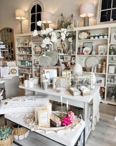 a room filled with lots of white furniture and flowers on top of it's shelves