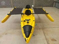 a yellow kayak sitting on top of a cement floor