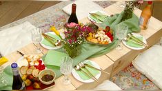 the table is set with plates, silverware, and flowers in vases on it