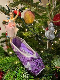 an ornament is hanging on a christmas tree with shoes and ornaments around it