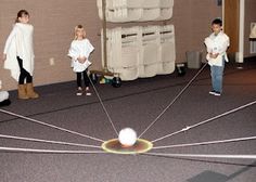 several children are playing with a ball in the middle of a room