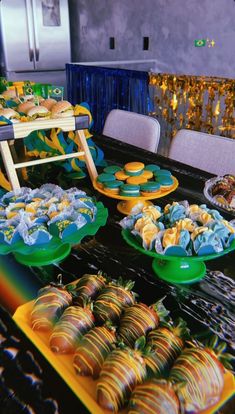 there are many desserts on the table and one is blue, yellow and green