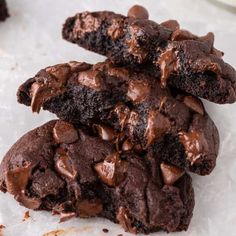 two chocolate cookies stacked on top of each other, with one broken in half and the other partially eaten