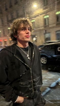 a young man is standing in the rain