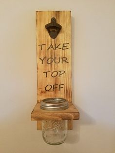 a mason jar hanging on a wooden shelf with the words take your top off