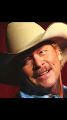 a man in a cowboy hat smiling at the camera