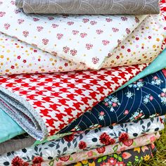 a pile of cloths sitting on top of each other in different colors and patterns