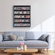 a living room with a gray couch and wooden coffee table in front of a white wall