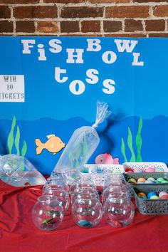 fishbowl tosses are lined up on a red tablecloth with plastic cups