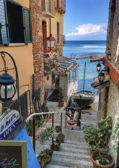 an alley way with stairs leading up to the water