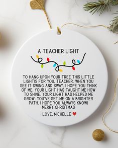 a teacher's light ornament on a table with christmas lights and ornaments