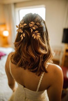 the back of a woman's head wearing a hair comb with leaves on it