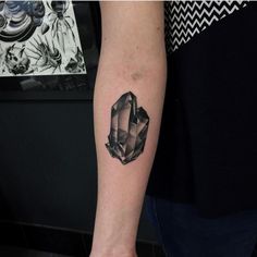 a woman's arm with a tattoo on it that has an image of a diamond