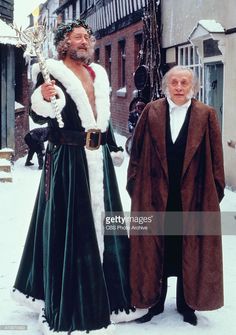 two men dressed as santa claus and an old man in winter clothes on the street