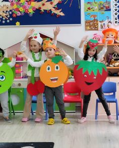 children in costumes holding up paper cutouts