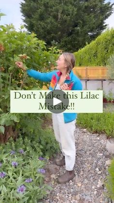 a woman standing next to a bush holding a sign that says don't make this lilac miske