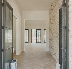 an empty room with brick walls and double doors leading to another room in the background