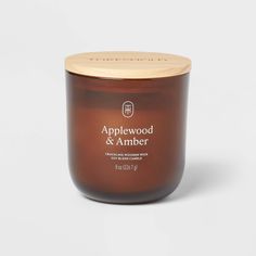 an applewood and amber candle on a white background