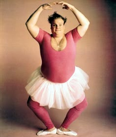 a woman in a pink leotard and white tutu poses for the camera