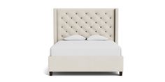 an upholstered bed with white linens and tufted headboard, on a white background