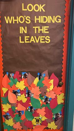 a door decorated with leaves and the words look who's hiding in the leaves