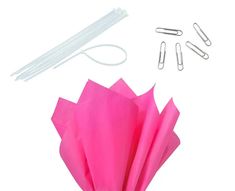 pink tissue paper, scissors and other items on white background