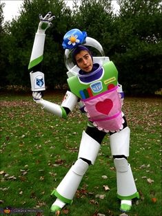 a man dressed as buzz lightyear from toy story in the grass with his arms outstretched