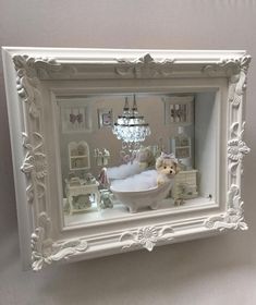 a white frame with a teddy bear in the bathtub and other items inside it