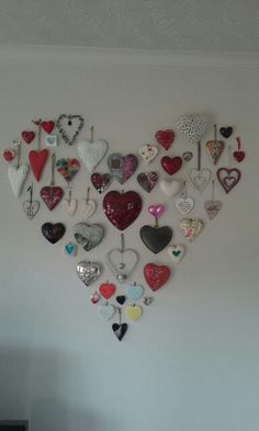 a white wall filled with lots of heart shaped magnets