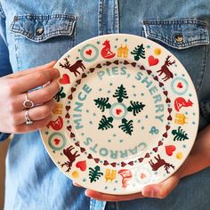 a person holding a plate with christmas designs on it