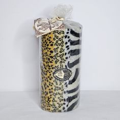 an animal print tube wrapped in plastic with a bow on the top and ribbon around it