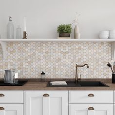 a kitchen with white cabinets and tile backsplash