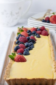 there is a lemon curd tart with berries on top