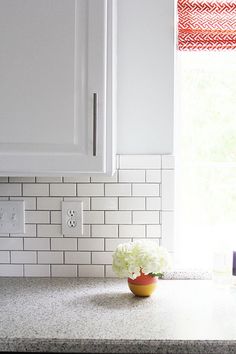 a bowl with flowers in it sitting on a kitchen counter