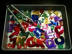 a tray filled with lots of different colored letters