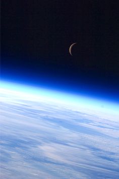 the moon is seen over the earth from space