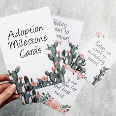 someone holding up some cards with cactus designs on them and the words adoption milestone cards written in black ink