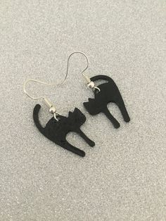 Black cat earrings. 27mm adorable black enamel painted zinc alloy cats fitted with 20mm zinc alloy hypoallergenic fish hook earring wires. Lead and nickel free. These sweet earrings will make a very special gift for any animal loving lady or a wonderful treat for yourself. Shipped in a pretty satin gift bag. Estimated shipping times - Business days : North America 5-15 Europe 5-15 Australia / New Zealand  7-21 United Kingdom  1-3 Please note that due to brexit, some overseas orders are subject to customs delays at the destination. Novelty Black Cat Design Jewelry, Black Cat Design Drop Earrings, Novelty Black Jewelry With Cat Design, Black Cat Design Novelty Jewelry, Black Novelty Jewelry With Cat Design, Black Novelty Drop Earrings, Black Cat Ears Jewelry With Cat Design, Black Cat Ears Jewelry For Gifts, Black Cat Ears Jewelry As A Gift