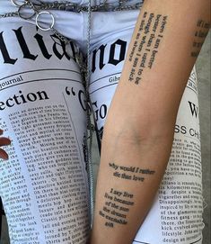 two people with tattoos on their arms are holding each other's hands and reading the newspaper