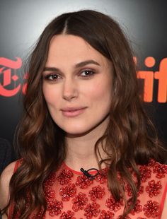 a woman with long brown hair wearing a red dress