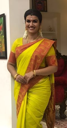 a woman in a yellow sari posing for the camera